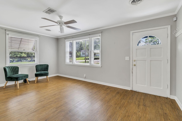 foyer with hardwood / wood-style flooring, crown molding, and ceiling fan