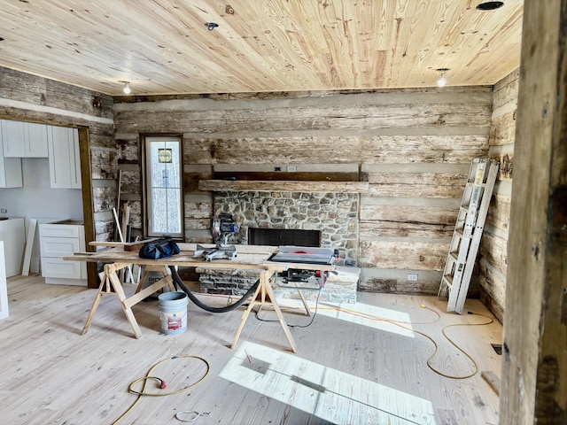 interior space with light hardwood / wood-style flooring, wood ceiling, and wooden walls