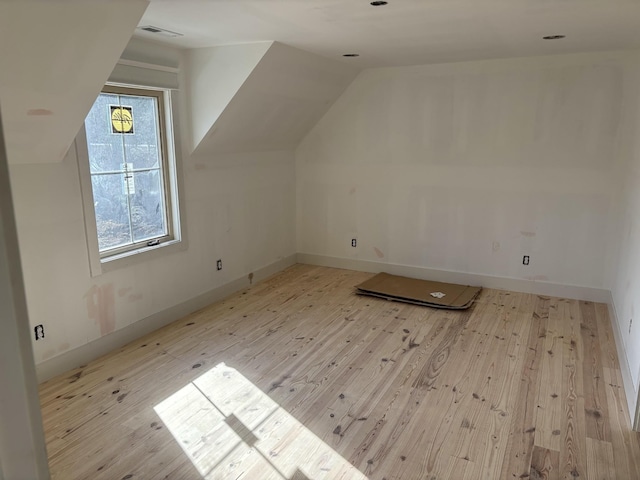 bonus room featuring vaulted ceiling and light hardwood / wood-style flooring