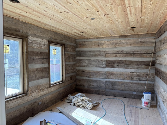 unfurnished room with hardwood / wood-style floors, wood ceiling, and wooden walls