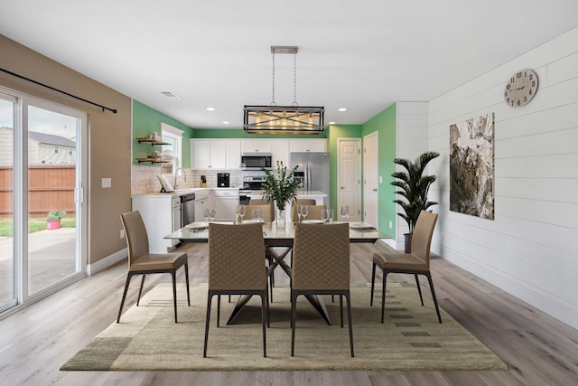 dining room with sink and light hardwood / wood-style flooring