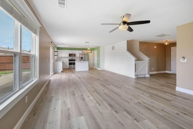 unfurnished living room with light hardwood / wood-style floors and ceiling fan