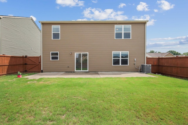 back of property with central AC, a patio area, and a lawn