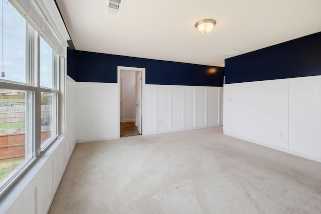 spare room featuring light colored carpet