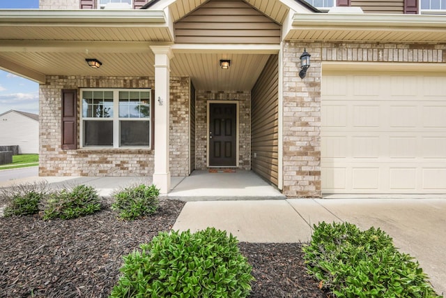 entrance to property featuring a garage and a porch