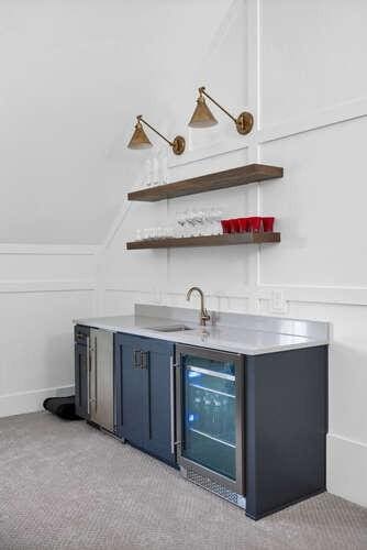 bar featuring beverage cooler, indoor wet bar, a sink, and light colored carpet