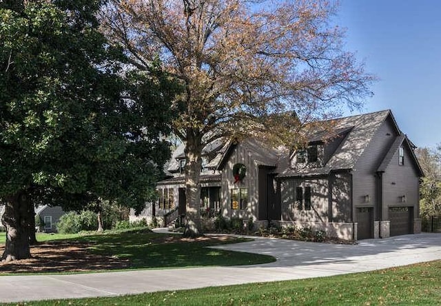 obstructed view of property featuring an attached garage, a front lawn, and concrete driveway