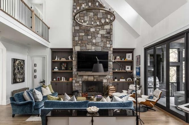 living room featuring high vaulted ceiling, a fireplace, and wood finished floors