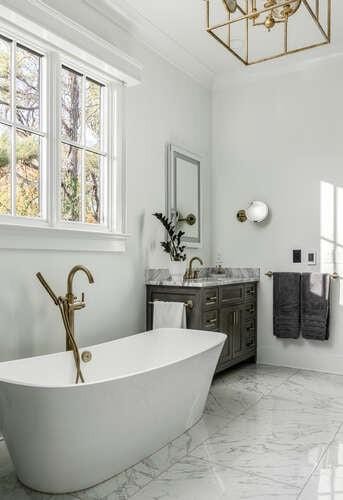 bathroom with marble finish floor, a freestanding tub, vanity, and crown molding