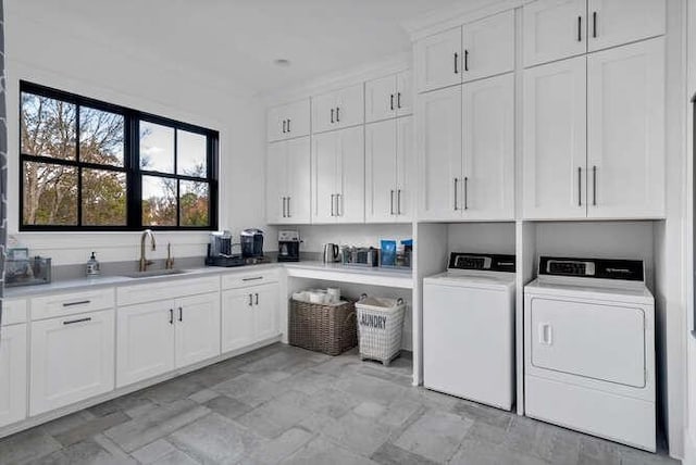 washroom featuring a sink, cabinet space, and washer and dryer