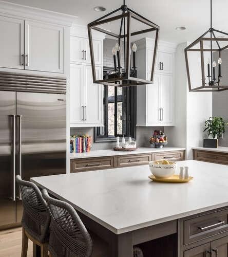 kitchen with built in fridge, light countertops, an inviting chandelier, and white cabinetry