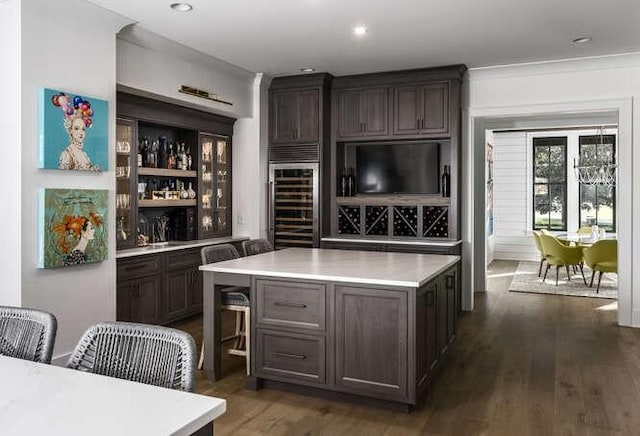 bar with dark brown cabinetry, dark wood-type flooring, and beverage cooler