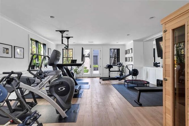 workout area with french doors, crown molding, and hardwood / wood-style flooring