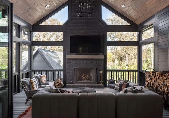 living room with a brick fireplace, a wealth of natural light, wooden ceiling, and high vaulted ceiling