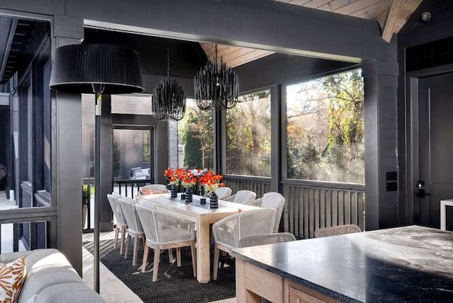 interior space featuring wood ceiling, lofted ceiling with beams, a wealth of natural light, and a notable chandelier