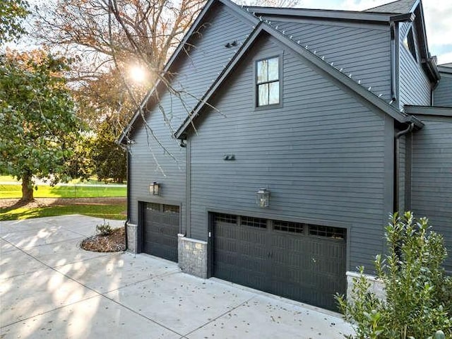 view of side of home featuring an attached garage