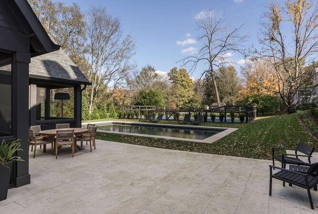 view of patio / terrace featuring a water view, outdoor dining area, and a fenced in pool