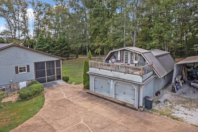 view of outbuilding with a sunroom and a lawn