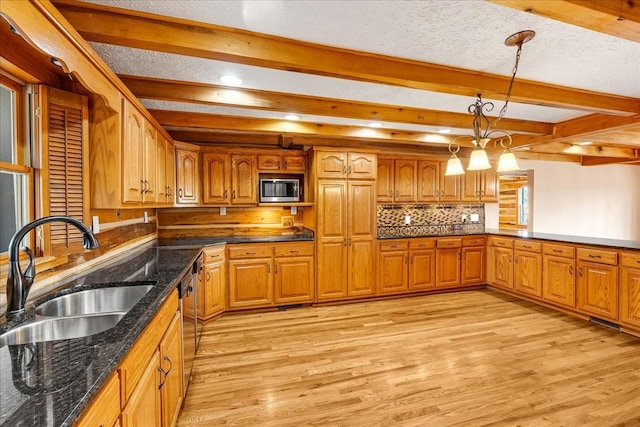 kitchen with appliances with stainless steel finishes, sink, decorative backsplash, hanging light fixtures, and beam ceiling