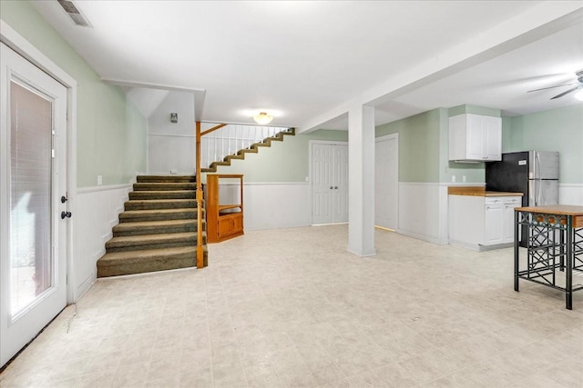 interior space with ceiling fan and stainless steel fridge