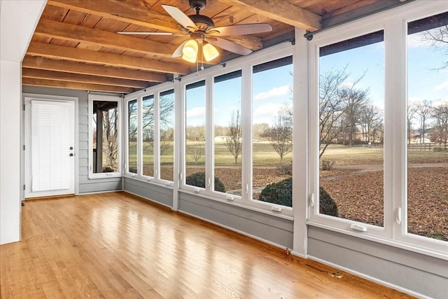 unfurnished sunroom featuring ceiling fan, wooden ceiling, and beamed ceiling