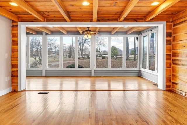 unfurnished sunroom with ceiling fan, wooden ceiling, and beam ceiling