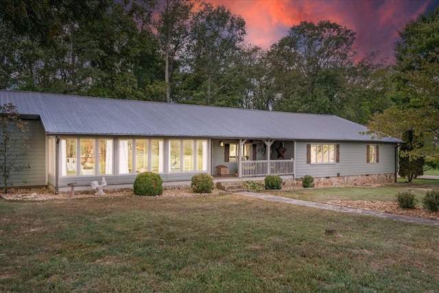 ranch-style home featuring a yard and a porch