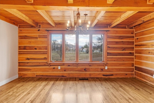 spare room with beamed ceiling, hardwood / wood-style floors, wooden ceiling, and a chandelier