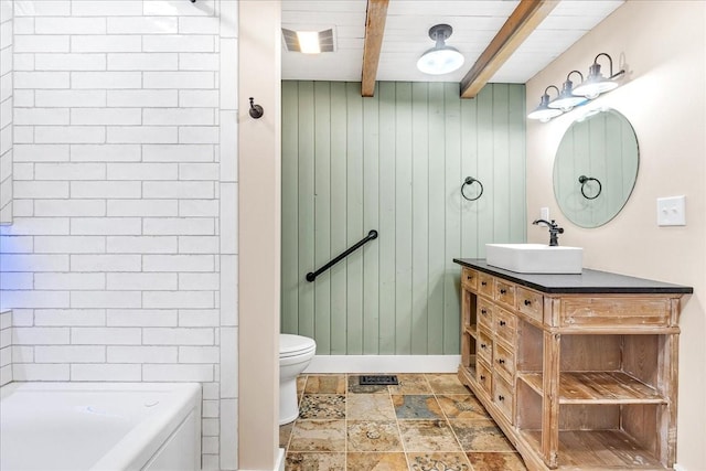 bathroom with beamed ceiling, wooden walls, vanity, and toilet