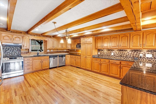 kitchen with decorative light fixtures, beamed ceiling, sink, stainless steel appliances, and light wood-type flooring