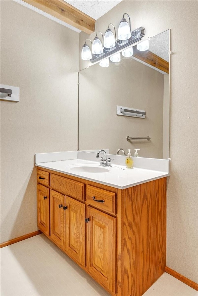 bathroom featuring vanity and beam ceiling