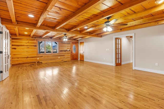 unfurnished living room featuring french doors, ceiling fan, wood ceiling, and wood walls