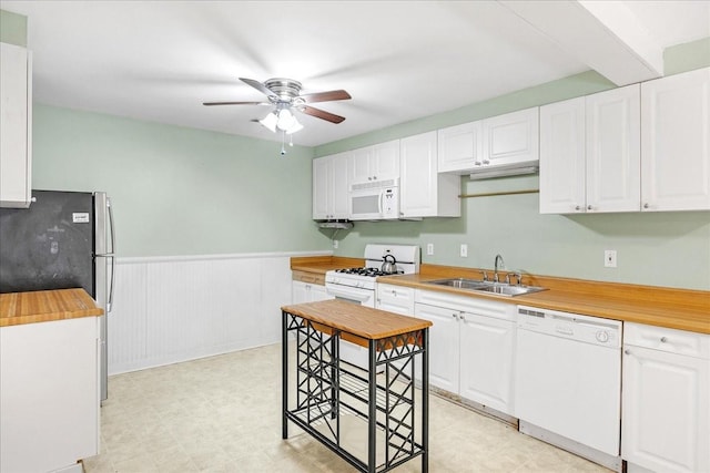 kitchen with sink, white appliances, wooden counters, ceiling fan, and white cabinetry