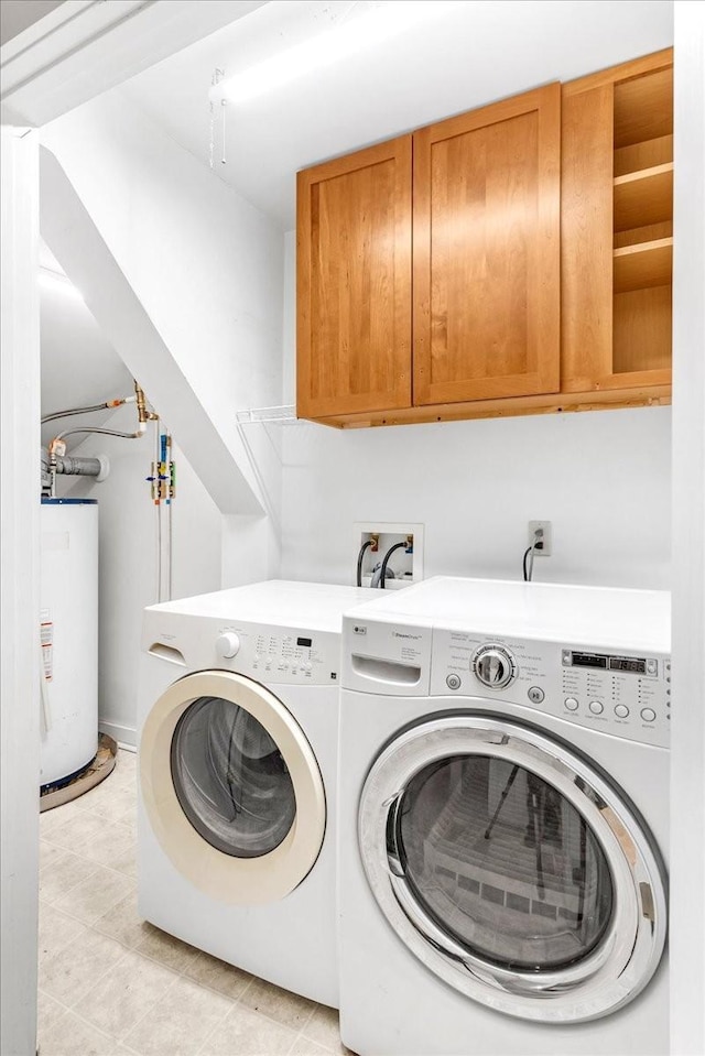 laundry room featuring washer and clothes dryer, gas water heater, and cabinets