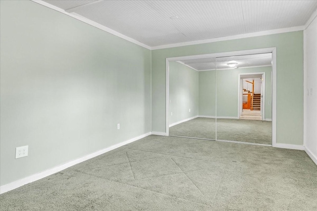 empty room with crown molding and carpet