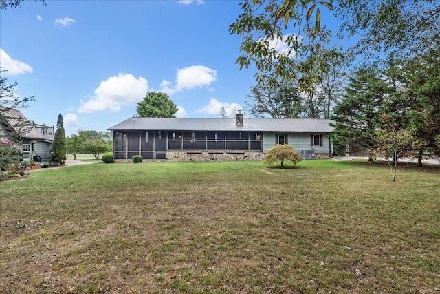 rear view of property with a sunroom, a yard, and central air condition unit