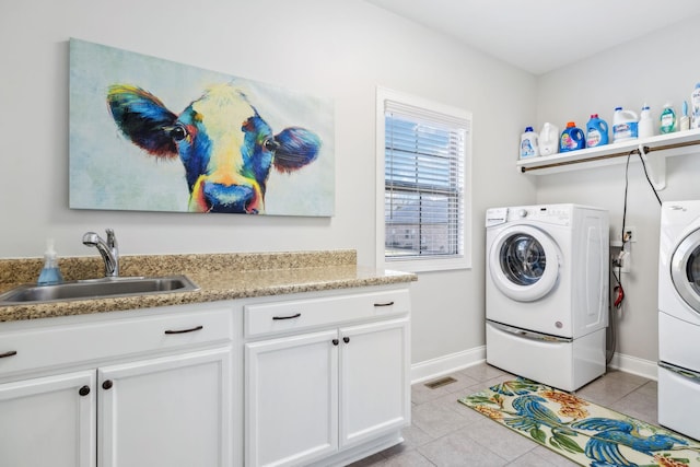 washroom with sink, light tile patterned floors, cabinets, and washing machine and clothes dryer