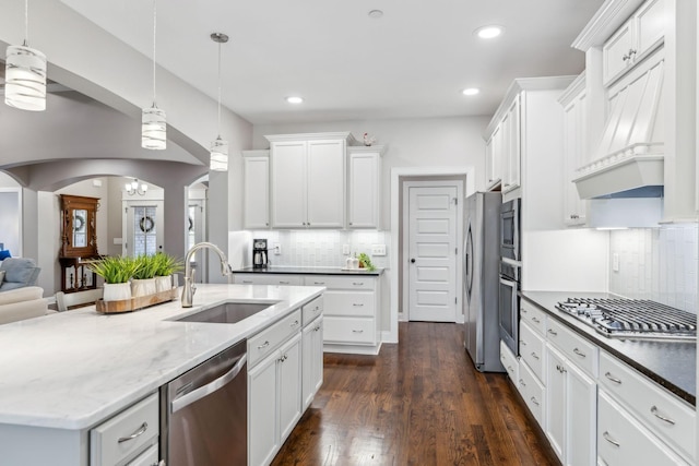 kitchen featuring stainless steel appliances, white cabinetry, sink, and pendant lighting