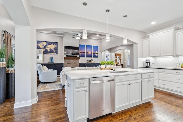 kitchen with sink, backsplash, white cabinets, a center island with sink, and stainless steel dishwasher