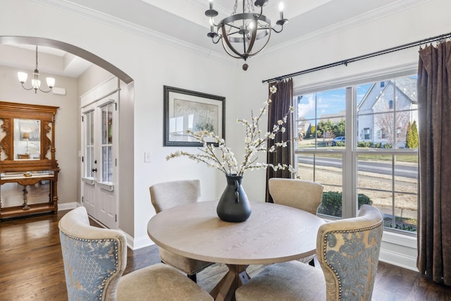 dining area with a raised ceiling, crown molding, dark hardwood / wood-style floors, and a notable chandelier