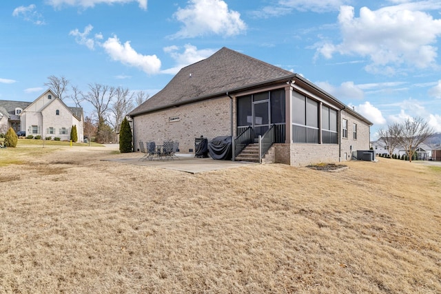 rear view of property with central AC, a patio area, a sunroom, and a lawn