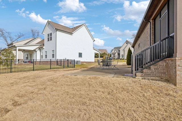 view of side of home featuring cooling unit, a yard, and a patio