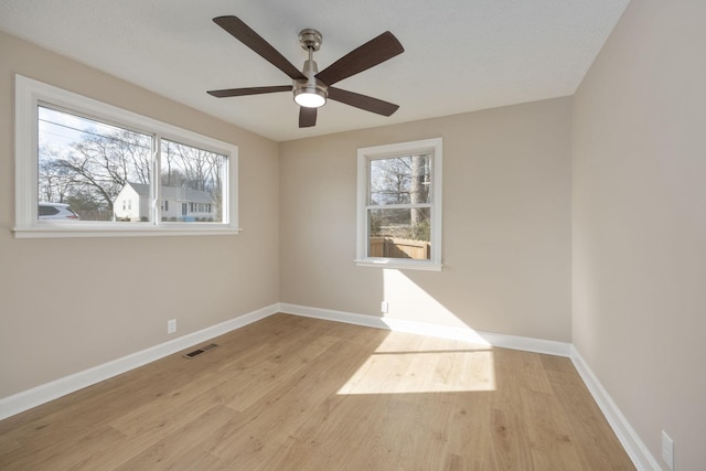 spare room featuring plenty of natural light, ceiling fan, and light hardwood / wood-style flooring