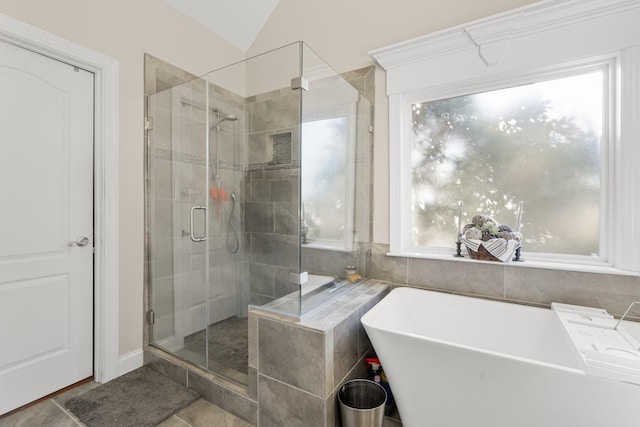 bathroom featuring lofted ceiling and independent shower and bath