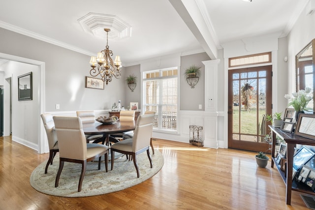 dining room featuring crown molding, light hardwood / wood-style flooring, and a notable chandelier