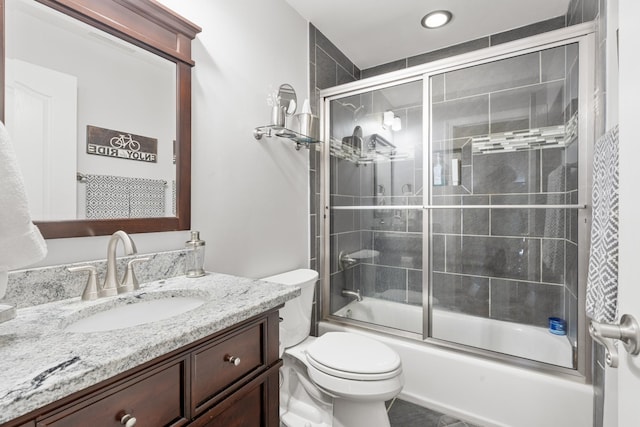 full bathroom featuring vanity, bath / shower combo with glass door, and toilet