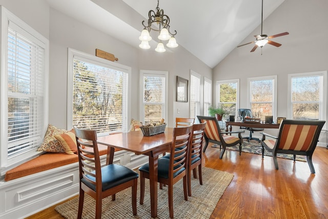 dining room featuring vaulted ceiling, ceiling fan with notable chandelier, and light hardwood / wood-style floors