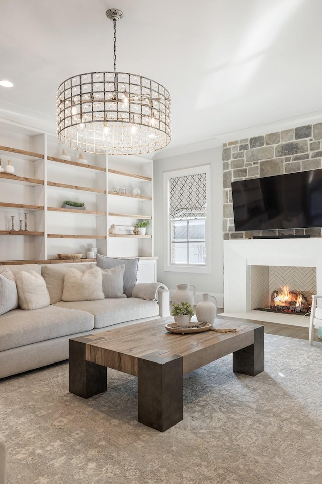 living room with a stone fireplace and ornamental molding