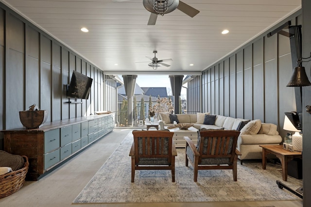 living room with ceiling fan and a wall of windows