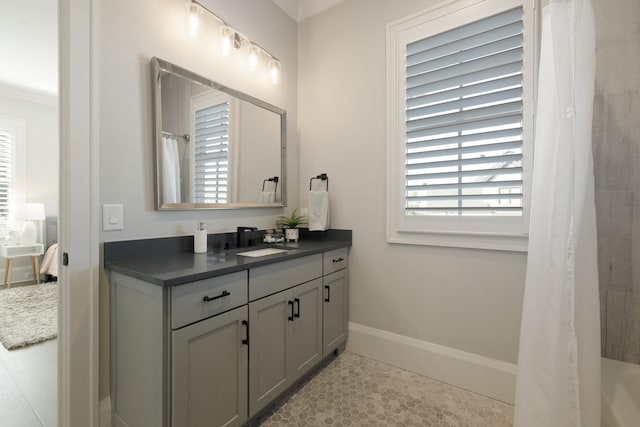 bathroom featuring vanity, tile patterned flooring, plenty of natural light, and ornamental molding